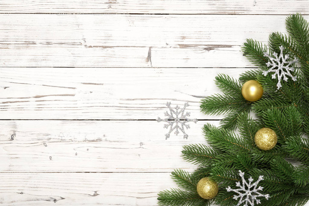 Різдвяний декоративний фон кордону з золотими кульковими прикрасами, срібною зіркою, іграшкою ялинки, ялинковими гілками на білому дереві сільської місцевості з копією. Плоский прошарок
 - Фото, зображення