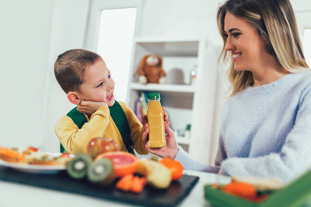 Матері прийняття сніданку за своєю дитиною вранці, а закуски для школи - Фото, зображення