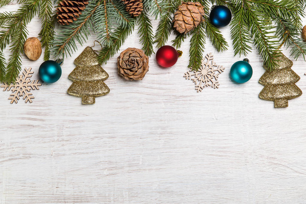 Fir branches with Christmas decorations on a wooden background. Copy space. - Photo, Image