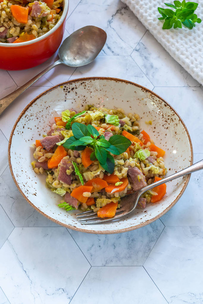 Pearl barley and bacon cassarole with carrots, leek and savoy cabbage - high angle view - Photo, Image