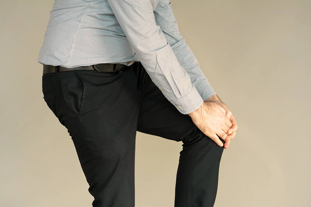 Pain In Knee. Close-up Businessman Leg With Painful Kneeson isolated. Man Feeling Joint Pain, Having Health Issues And Touching Leg With Hands. Body And Health Care Concept. - 写真・画像