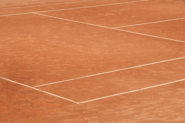 Part of empty used red clay tennis court playground surface with white lines closeup - Фото, зображення