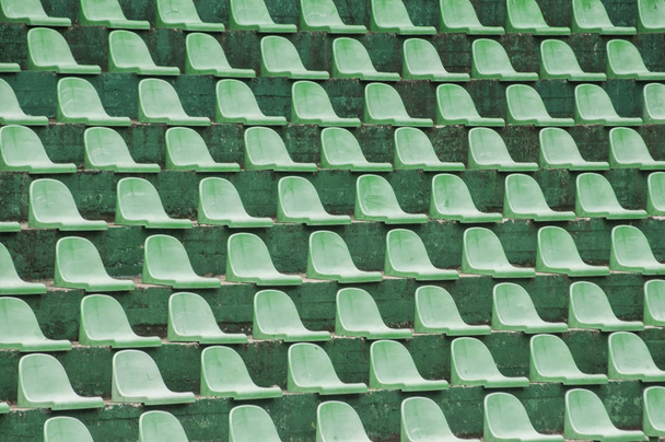 Пустые зеленые пластиковые зрительские места крупным планом на теннисном корте
 - Фото, изображение