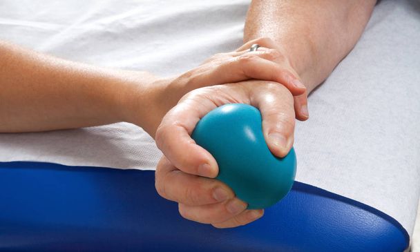 Stimolazione della mano femminile utilizzando esercizio palla blu con l'aiuto del fisioterapista
 - Foto, immagini