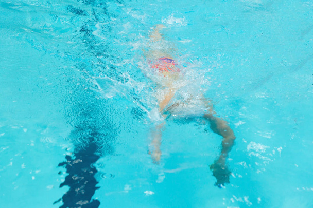 A young boy pounds in the pool. - Foto, Bild