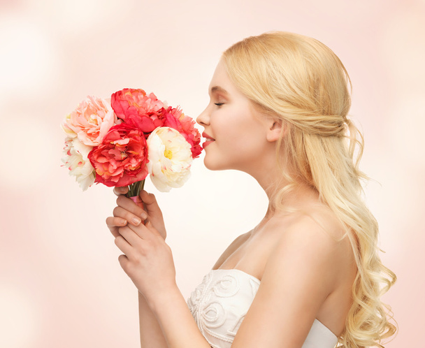 Woman smelling bouquet of flowers - Photo, Image
