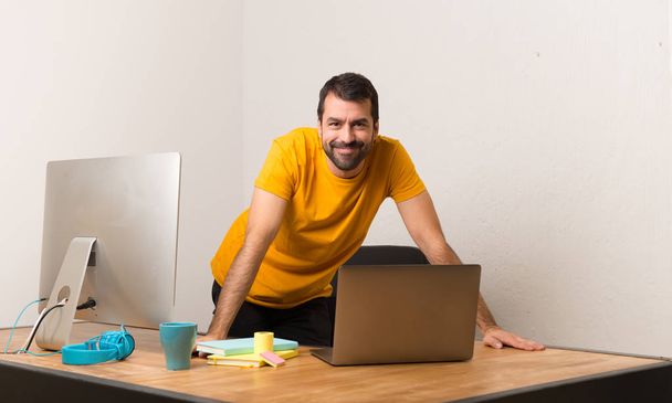 Happy man working with laptot in a office - Valokuva, kuva