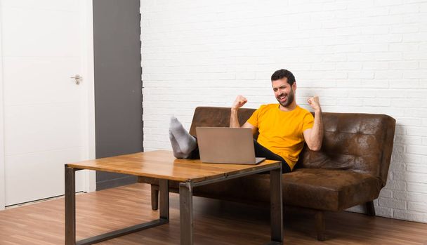 Człowiek z laptopem w pokoju świętuje zwycięstwo - Zdjęcie, obraz