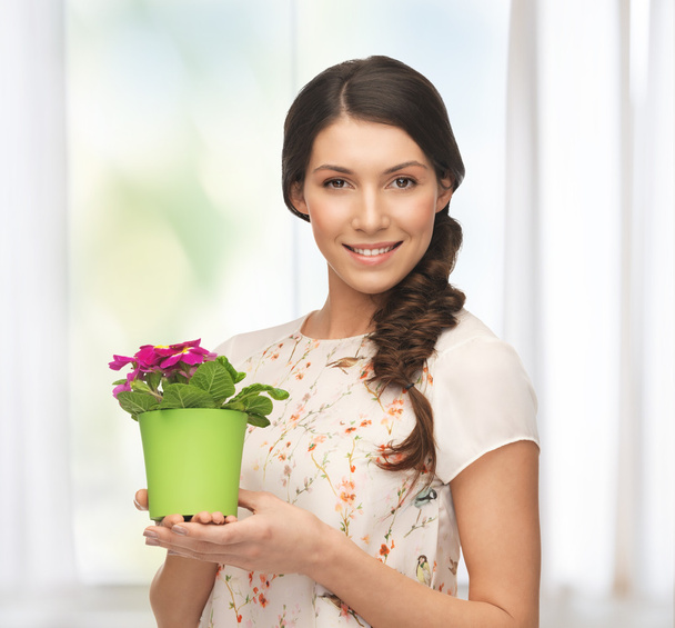 Lovely housewife with flower in pot - Zdjęcie, obraz