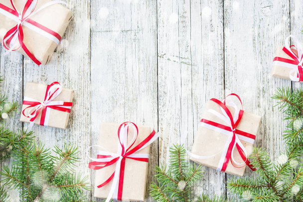 Κουτιά δώρων στα σύνορα των Χριστουγέννων και υποκατάστημα δέντρο έλατο στο χιόνι ξύλινο τραπέζι. Το Top view με αντίγραφο χώρου - Φωτογραφία, εικόνα