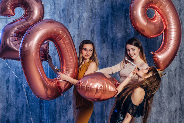 Lindas jovens mulheres comemorando jogar segurando balões. Ano Novo, Natal, Natal
 - Foto, Imagem