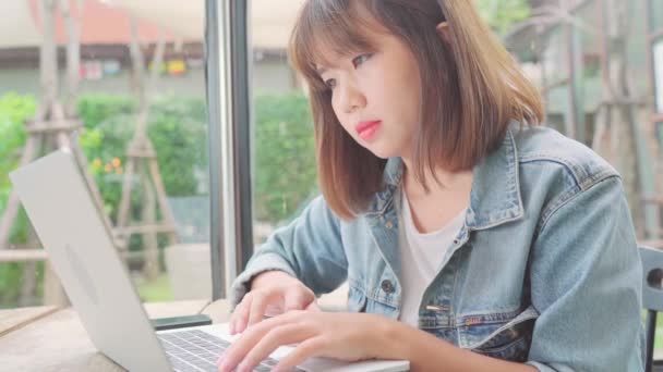 Business freelance Asian woman working, doing projects and sending email on laptop or computer while sitting on table in cafe. Lifestyle smart beautiful women working at coffee shop concepts. - 映像、動画
