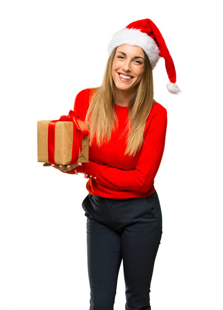 Blonde woman dressed up for christmas holidays keeping the arms crossed while smiling on isolated white background - Foto, Imagen