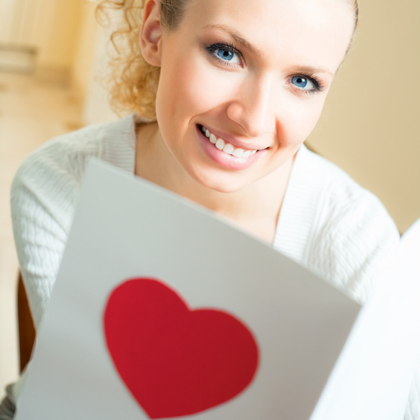 Cheerful smiling woman, reading valentine card - Photo, Image