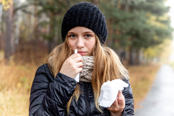 young woman with runny nose and using a nasal spray - Photo, image