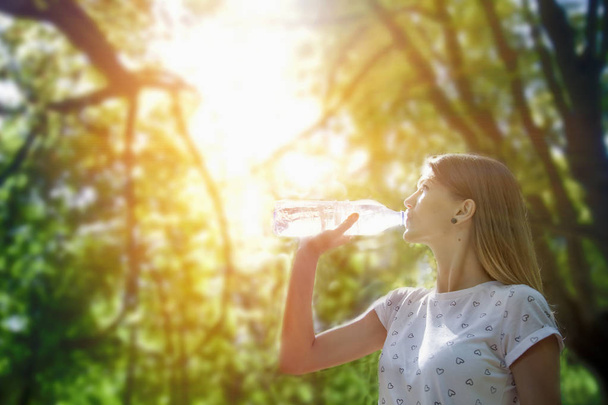 Giovane escursionista donna che beve acqua in una foresta
 - Foto, immagini