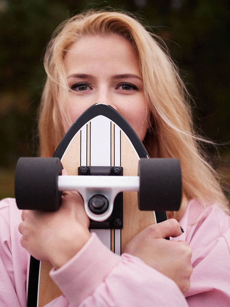 Bella bionda hipster donna in posa nel parco con skateboard longboard
 - Foto, immagini