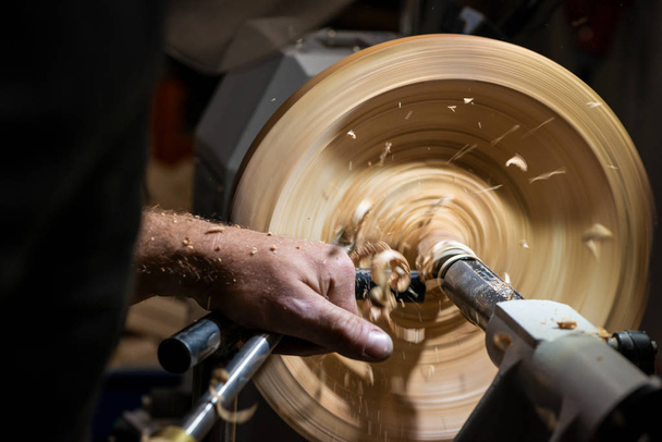 making a hole into a wooden bowl on turnery machine with chisel  - Photo, Image