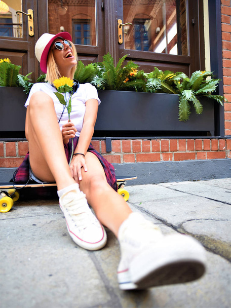 jeune femme avec skateboard dans la rue - Photo, image