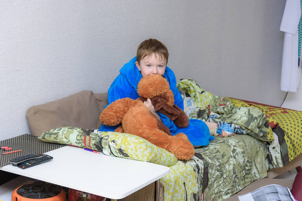 Portrait d'enfant mignon heureux 7 ans dans la chambre à la maison en famille sur le lit. Il est directement devant la caméra dans différentes poses
. - Photo, image