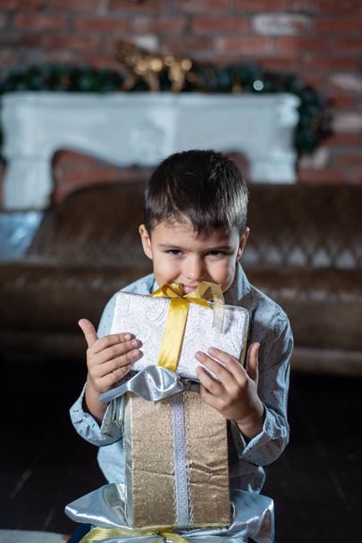 A little boy with a gift box on the floor. Merry Christmas - Zdjęcie, obraz