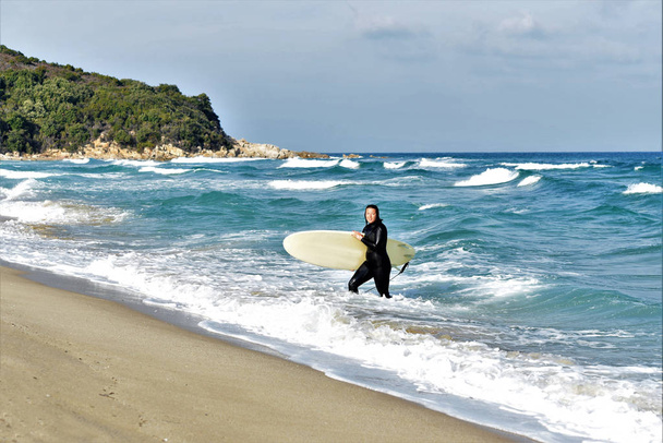 Sahilde sörf tahtası olan kadın sörfçü. - Fotoğraf, Görsel