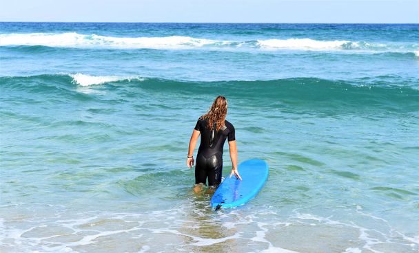 joven feliz con tabla de surf en la playa - Foto, Imagen
