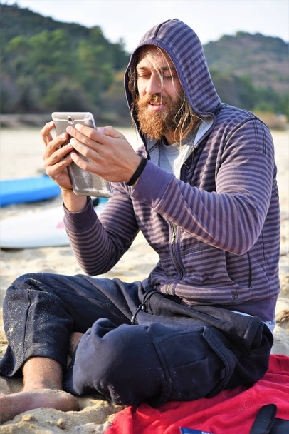 uomo con zaino seduto sulla spiaggia - Foto, immagini