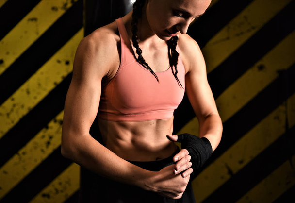 young woman with a barbell on a black background - Photo, Image