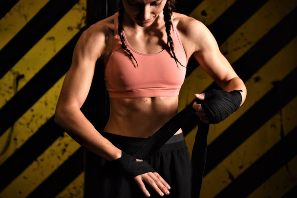 young woman with boxing gloves on a black background - Photo, Image