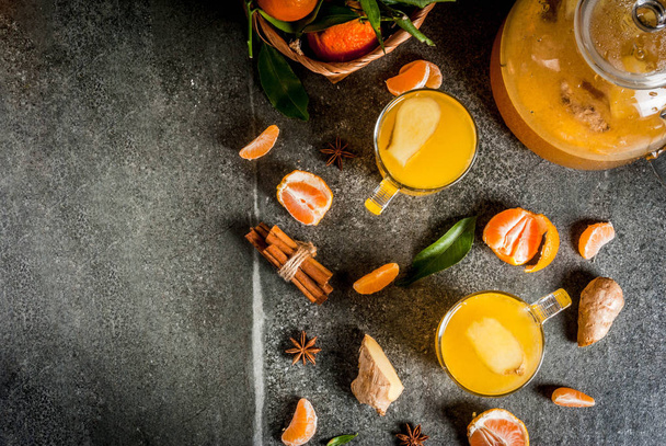 Tangerine Ginger Tea with cinnamon and anise, with ingredients, on dark stone background, copy space top view - Foto, Imagem