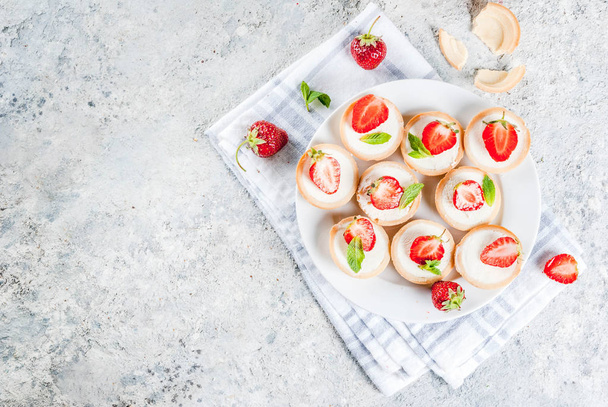 Summer sweet homemade dessert, Mini cheesecakes with strawberry on grey stone table copy space top view - Photo, Image