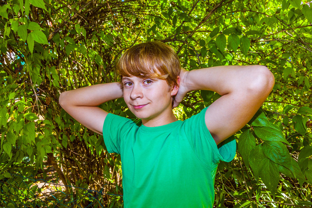 Χαριτωμένο έξυπνο αγόρι στον κήπο κάτω από το δέντρο - Φωτογραφία, εικόνα