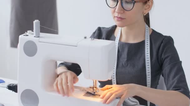 Concepto de hobby y pequeña empresa. Mujer sastre trabajando en la máquina de coser
 - Imágenes, Vídeo