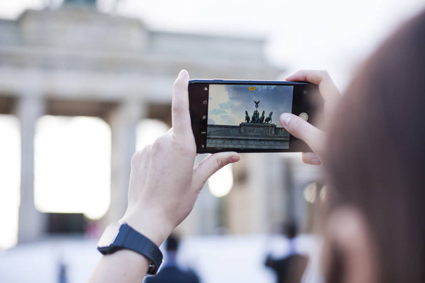 Руки проведення мобільний телефон і приймає фотографії Бранденбург Гат - Фото, зображення