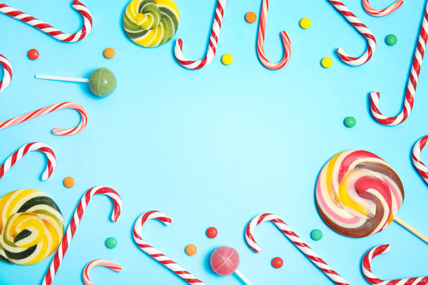Flat lay composition with tasty candy canes and space for text on color background - Foto, Bild