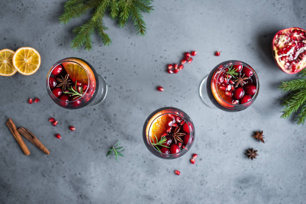 Red Sangria with oranges, pomegranate seeds, cranberry, rosemary and spices - homemade festive drink mulled wine for Christmas time. - Foto, immagini