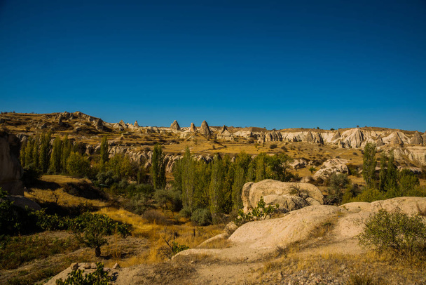 Región de Goreme, Capadocia, Anatolia, Turquía: Hermosa vista del valle con rocas y montañas. Paisaje en el soleado clima otoñal
. - Foto, Imagen