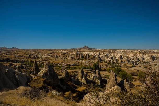 Cappadocia, Turkey: Beautiful landscape on the panorama of mountains and rocks. The fortress of Uchisar on the horizon. Love Valley, Gorkundere. - Фото, зображення