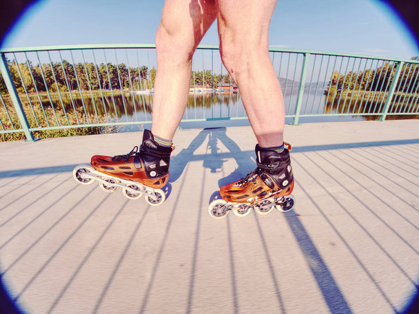 Doksy range, Czech Republic, 9th of October 2018.  Man roller skater in speed hard shell skates. Man try trick on the pathway against the sun - Photo, Image