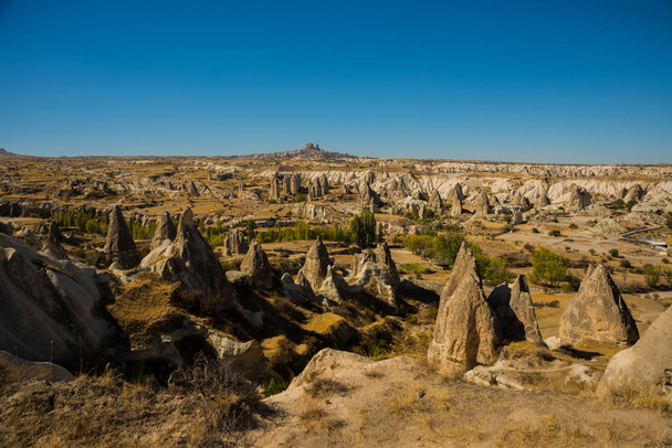 Cappadocia, Turkey: Beautiful landscape on the panorama of mountains and rocks. The fortress of Uchisar on the horizon. Love Valley, Gorkundere. - Fotoğraf, Görsel