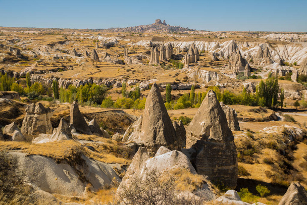 Cappadocia, Turkey: Beautiful landscape on the panorama of mountains and rocks. The fortress of Uchisar on the horizon. Love Valley, Gorkundere. - Φωτογραφία, εικόνα