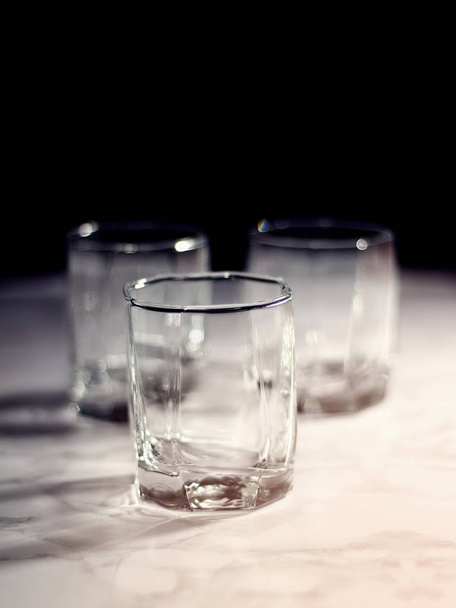 Empty old fashion glass on black background - 写真・画像