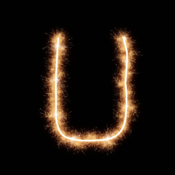 Letter U of alphabet written by squib sparks on a black background. - Foto, afbeelding