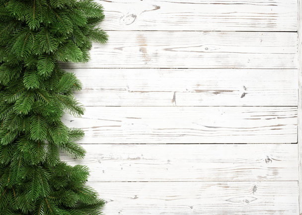 Fondo natalizio con rami di abete su tavoletta di legno bianca con spazio copia. Vista dall'alto
 - Foto, immagini