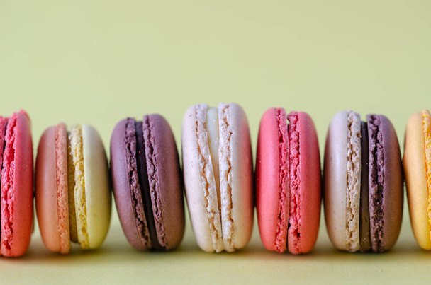 Colorful macaroons are on the light yellow background,copy space. - Photo, Image