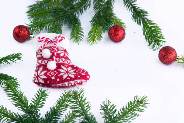 Medias rojas de Navidad y bolas de decoración sobre fondo blanco, marco de ramas de abeto verde - Foto, imagen