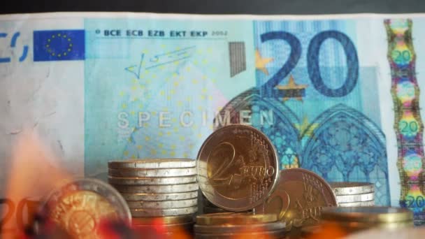 20 euró - 20 és az euro-érmék éget a tűz a fekete háttér. Zárja be az európai valuta van tűz. Tőzsdei összeomlást és a pénznem értékcsökkenés fogalma. 4 k. fogalmi pénzügyi kép - Felvétel, videó
