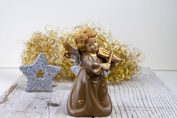 Ангел з скрипки перед золотим волоссям і срібні зірки на білий дерева Різдва тла - Фото, зображення