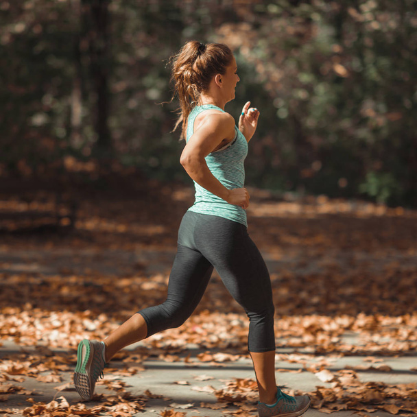 Woman Jogging in Public Park in The Fall   - Фото, зображення